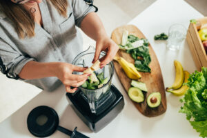 vrouw maakt smoothies met avocado 